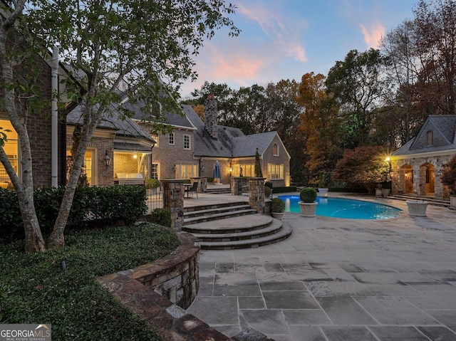 pool at dusk with a patio