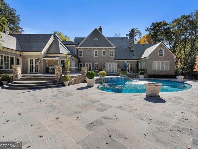 view of swimming pool featuring french doors and a patio area