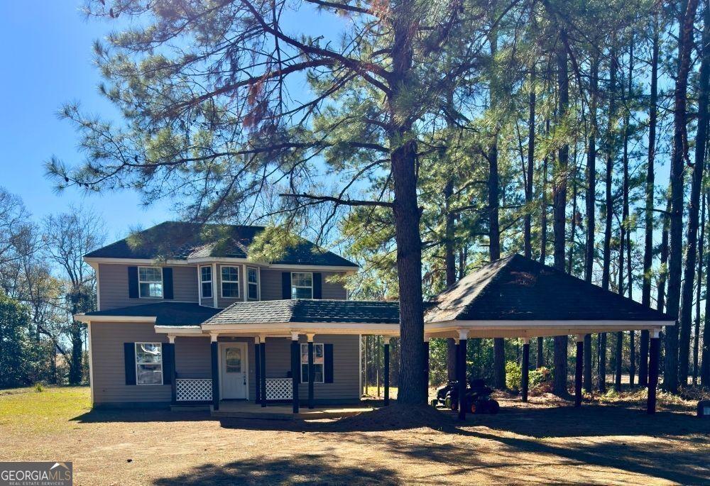 view of front of home with driveway, a carport, and a porch