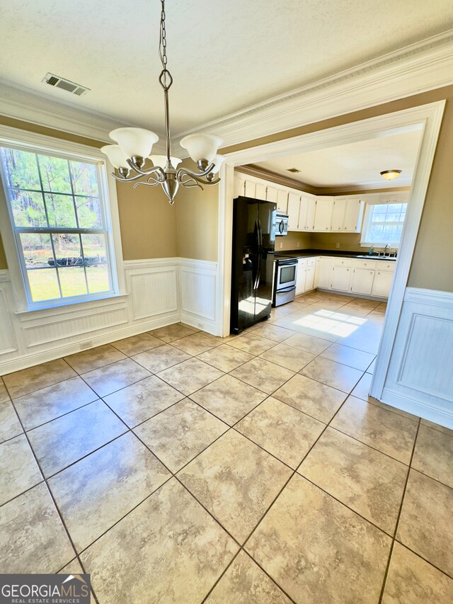 unfurnished dining area featuring crown molding and a notable chandelier