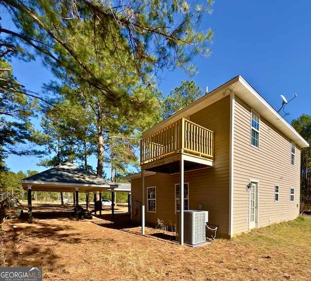 view of property exterior with a gazebo, cooling unit, and a balcony