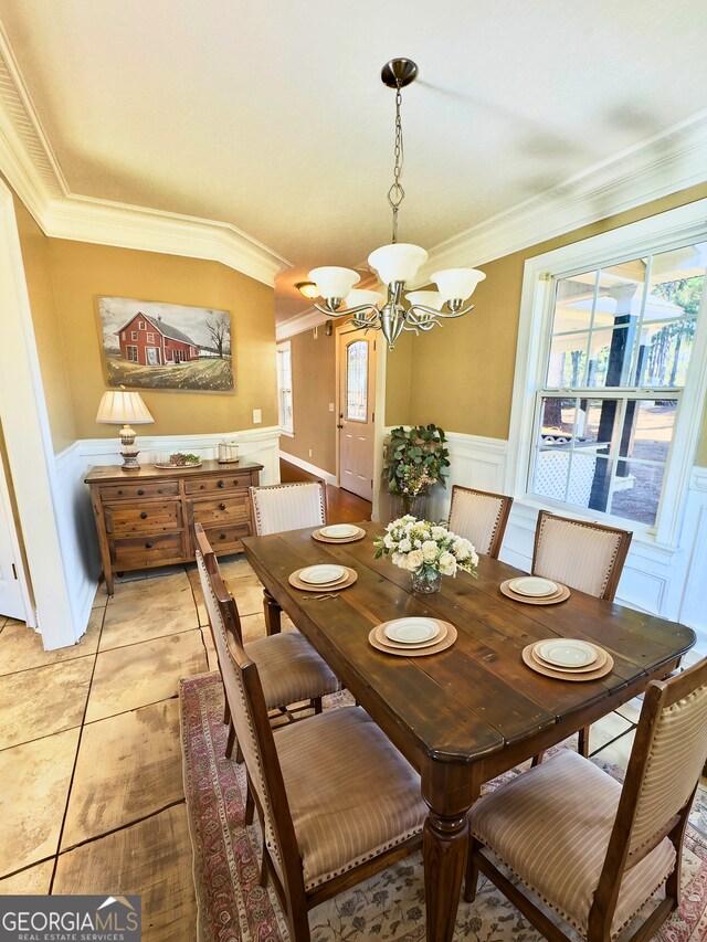 kitchen featuring black fridge, white cabinetry, ornamental molding, and a notable chandelier