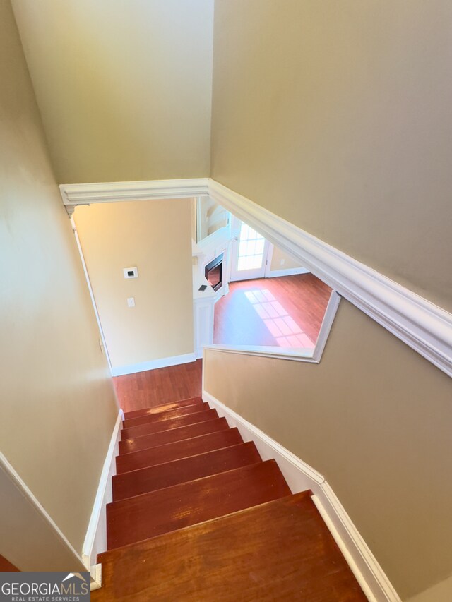 hallway with dark wood-type flooring and ornamental molding