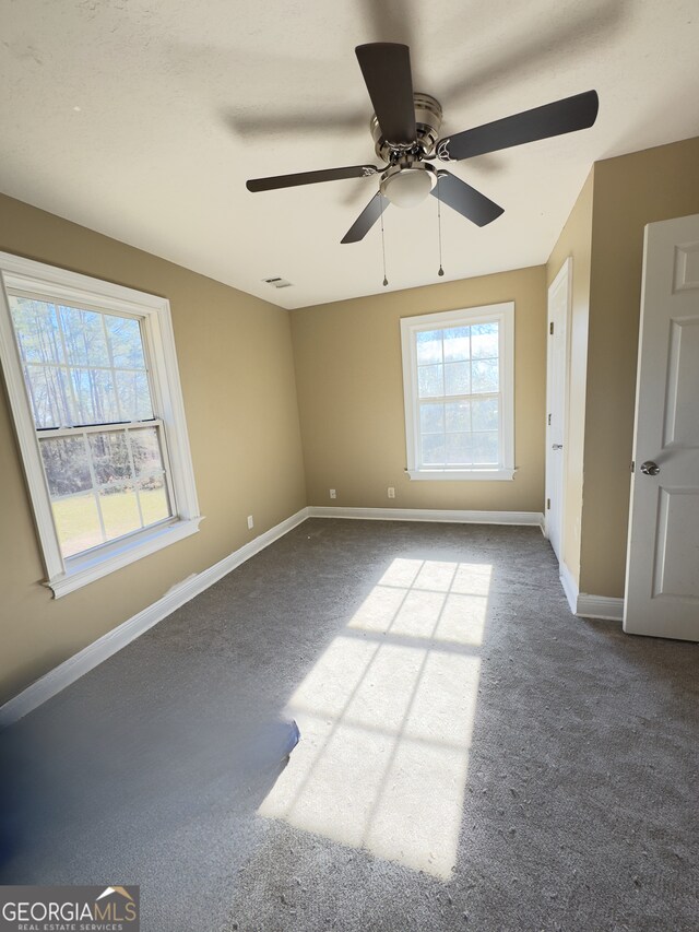 bedroom with ceiling fan, multiple windows, and carpet