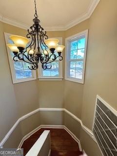 interior space with a notable chandelier, crown molding, and hardwood / wood-style flooring