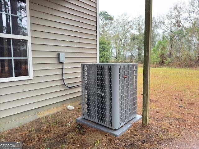 view of property exterior with central air condition unit and a lawn