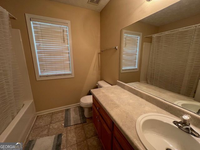 full bathroom with toilet, vanity, and shower / bath combo with shower curtain