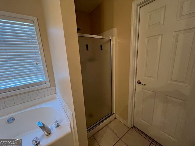 bathroom with independent shower and bath and tile patterned floors