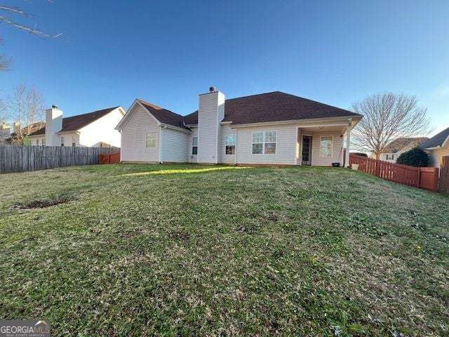 back of house featuring a lawn