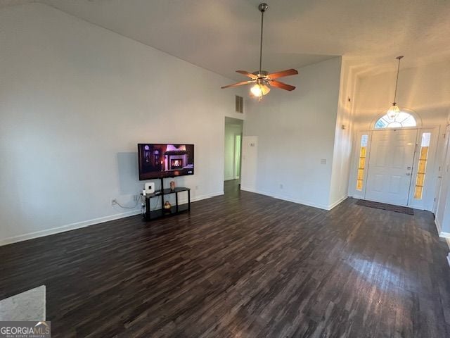 unfurnished living room with ceiling fan, dark wood-type flooring, and high vaulted ceiling