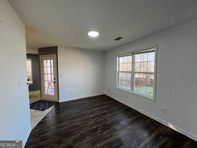 unfurnished room with dark hardwood / wood-style floors