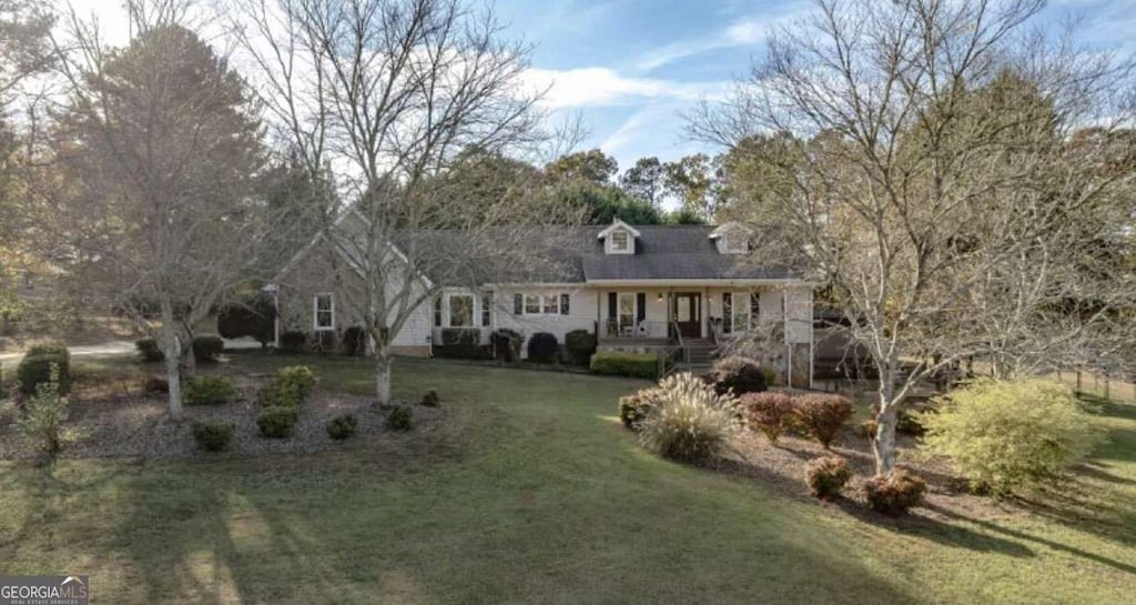 cape cod-style house featuring covered porch and a front yard