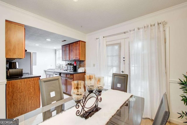 kitchen featuring appliances with stainless steel finishes, sink, a textured ceiling, and ornamental molding