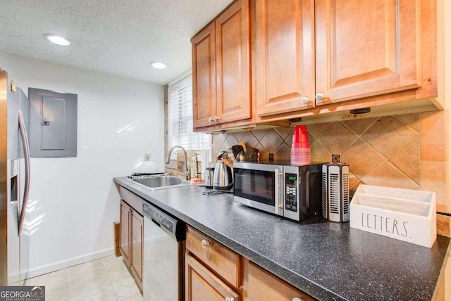 kitchen featuring stainless steel appliances, backsplash, a textured ceiling, electric panel, and sink