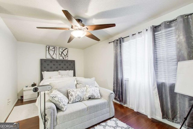 bedroom with ceiling fan, dark hardwood / wood-style floors, and a textured ceiling