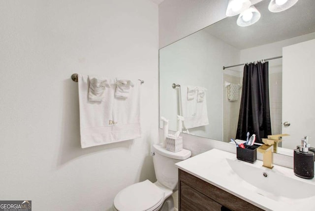 bathroom with toilet, vanity, and walk in shower