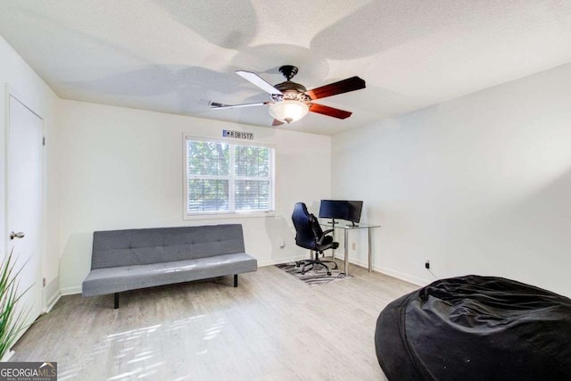 office area with ceiling fan, a textured ceiling, and light wood-type flooring