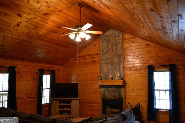 unfurnished living room featuring wooden walls, a fireplace, and vaulted ceiling