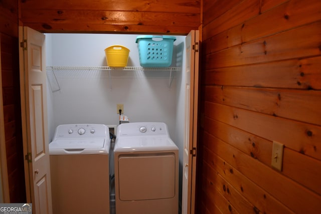 laundry room featuring independent washer and dryer and wooden walls