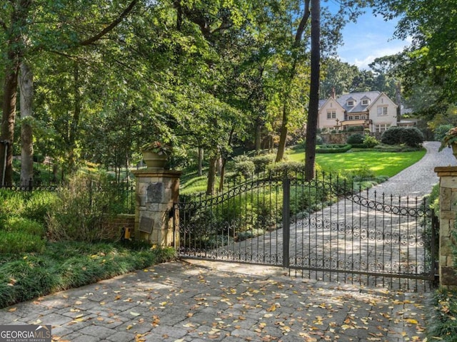 view of gate with a lawn