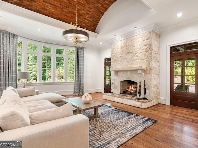 4345 Mount Paran Pkwy NW, Atlanta, GA 30327 - living room featuring vaulted ceiling, hardwood / wood-style flooring, a stone fireplace, baseboards, and crown molding