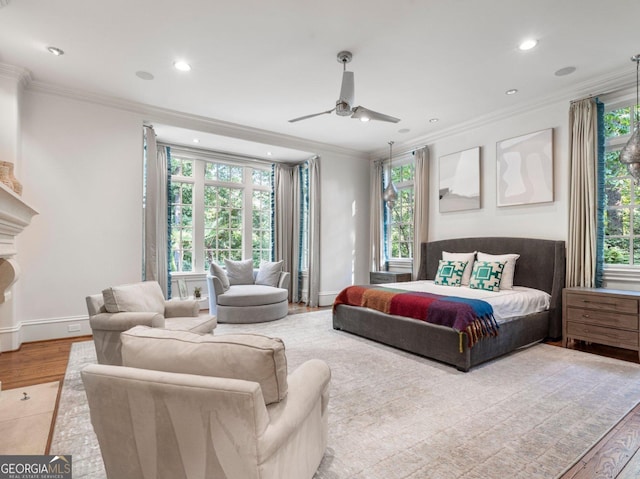 bedroom featuring multiple windows, ornamental molding, and wood finished floors