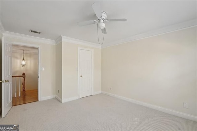 unfurnished bedroom with light colored carpet, crown molding, baseboards, and ceiling fan