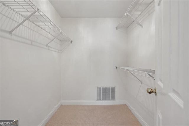walk in closet featuring light carpet