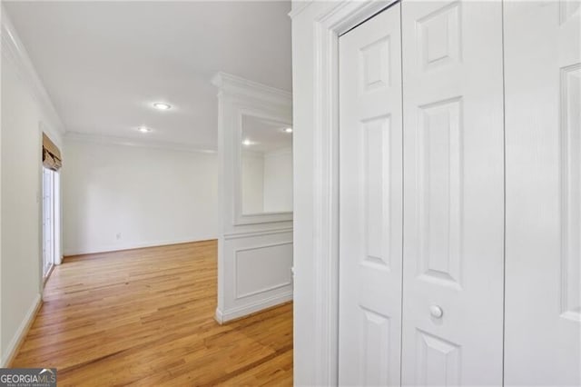 corridor with ornamental molding, light wood-type flooring, recessed lighting, and baseboards