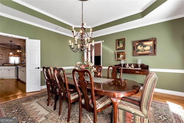 living room featuring wood-type flooring, a brick fireplace, ornate columns, ornamental molding, and ceiling fan