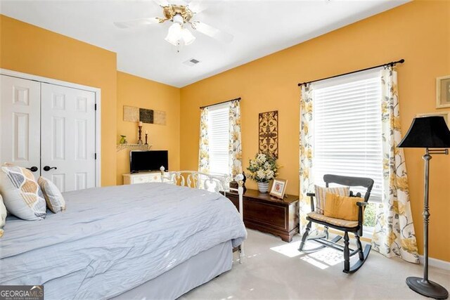 carpeted bedroom with ceiling fan, ornamental molding, a raised ceiling, and french doors