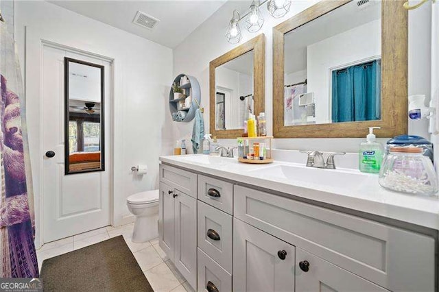 bathroom featuring toilet, vanity, and tile patterned flooring