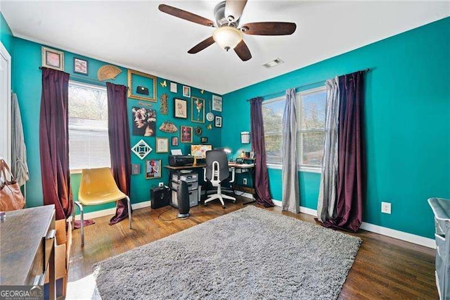 home office with ceiling fan and dark hardwood / wood-style floors