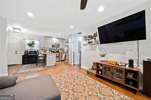 living room featuring light wood-type flooring and ceiling fan