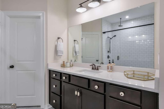 bathroom with a shower with shower door and vanity