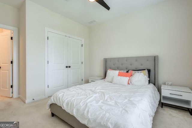 bedroom with ceiling fan, a closet, and light carpet