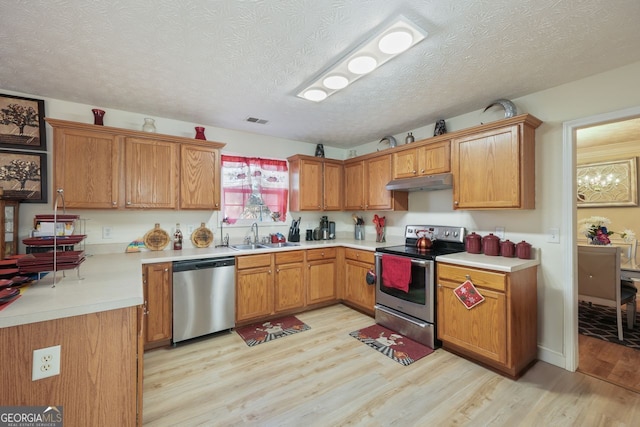 kitchen featuring light hardwood / wood-style floors, sink, a textured ceiling, and appliances with stainless steel finishes