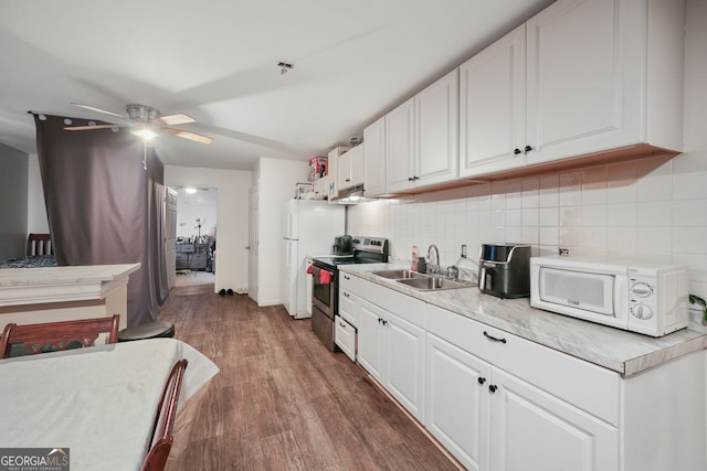 kitchen featuring sink, white cabinets, electric stove, hardwood / wood-style floors, and decorative backsplash