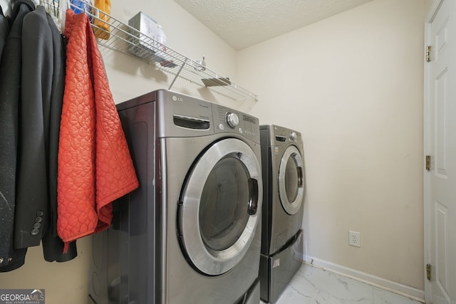 clothes washing area featuring washer and dryer and a textured ceiling