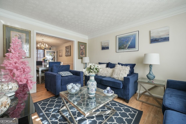 living room featuring hardwood / wood-style flooring, a textured ceiling, crown molding, and a chandelier