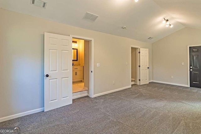 carpeted empty room with lofted ceiling