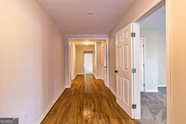 hall with dark colored carpet