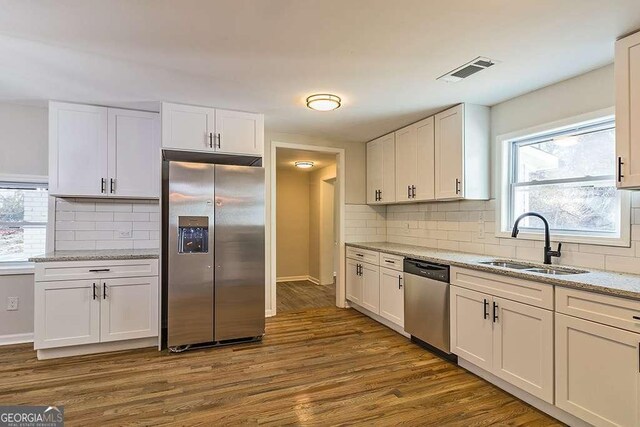 kitchen featuring white cabinetry, a sink, appliances with stainless steel finishes, and visible vents