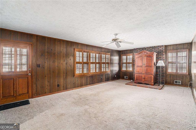 interior space featuring a textured ceiling, ceiling fan, and carpet floors