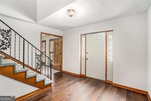 foyer entrance featuring dark hardwood / wood-style flooring and a textured ceiling