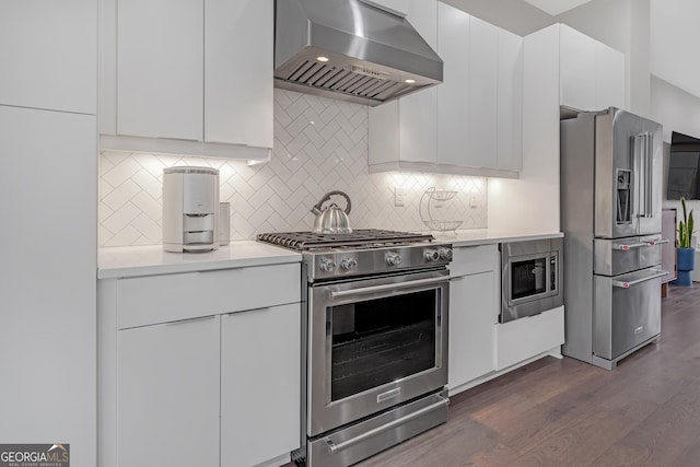 kitchen featuring backsplash, extractor fan, white cabinetry, dark hardwood / wood-style flooring, and high quality appliances