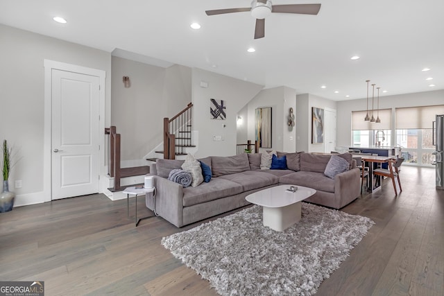 living room featuring dark wood-type flooring, ceiling fan, and sink