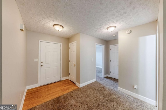 carpeted entryway featuring a textured ceiling