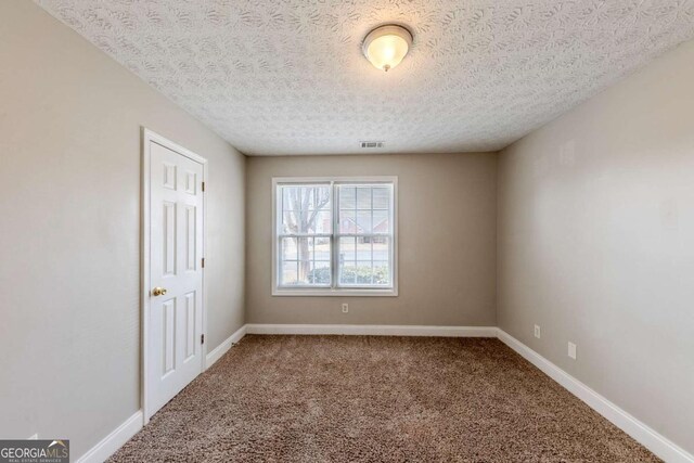 spare room with carpet floors and a textured ceiling