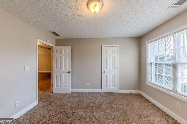 unfurnished bedroom featuring carpet floors and a textured ceiling